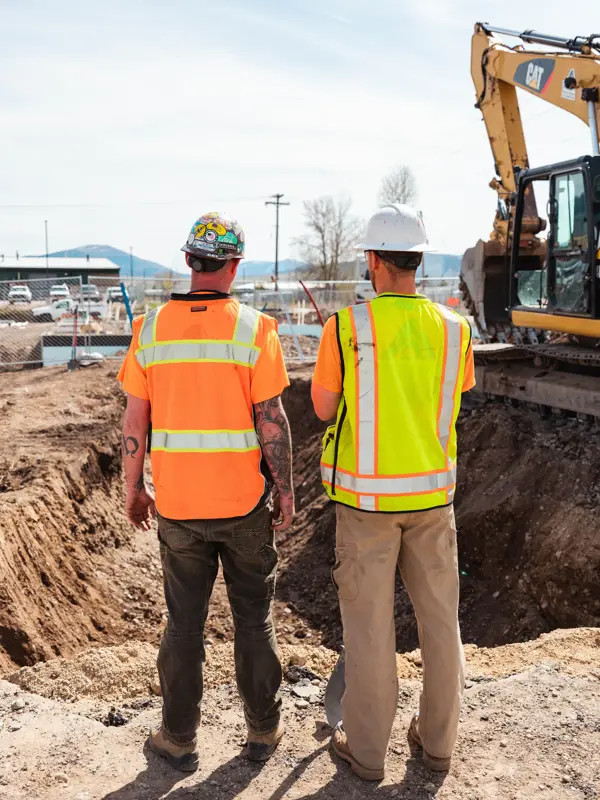 Site walk beside an excavator